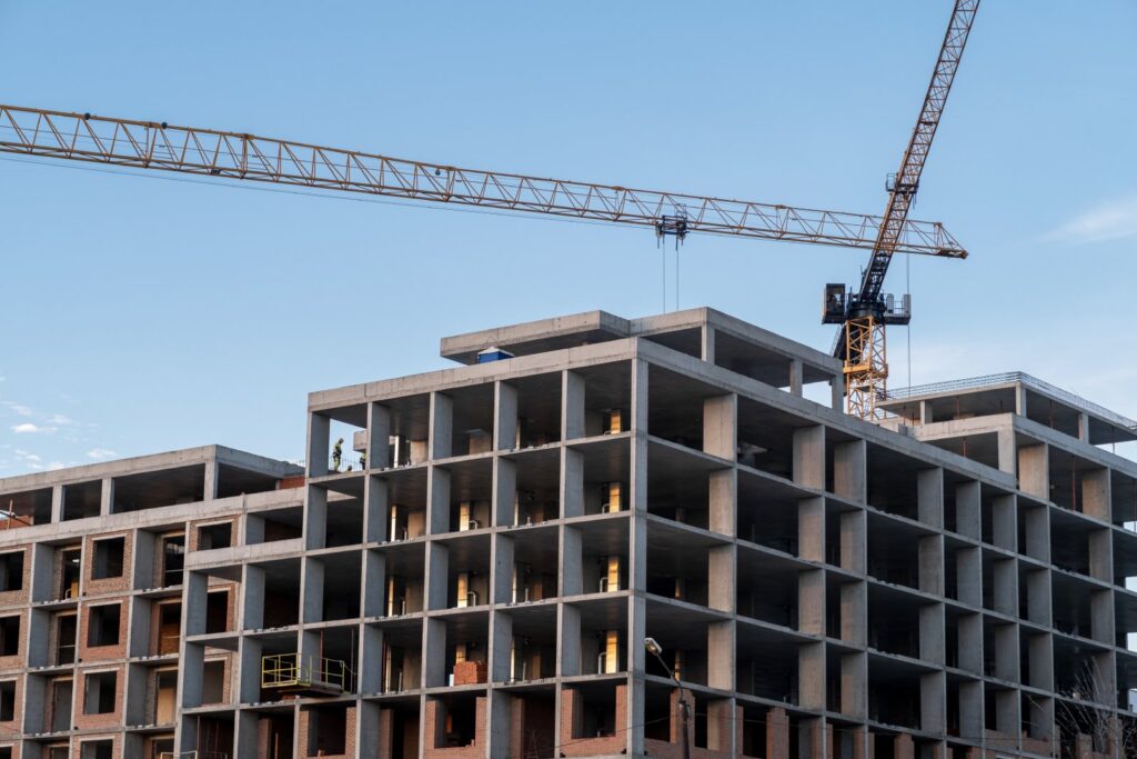 crane and a building under construction against a blue sky background